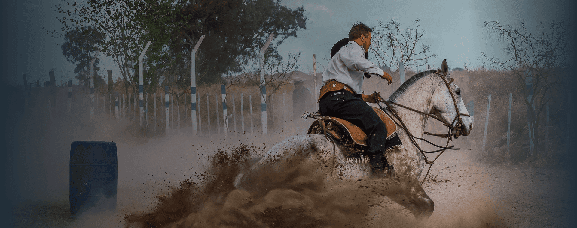 Horseback rider in traditional gaucho attire kicks up dust as he makes a turn. Overlaid is the Spanish word "gaucho" with its English translation, "skilled horseman".